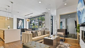 A modern living room with a sofa, ottoman, coffee table, and a fireplace. - Parkite on Main (Park City)