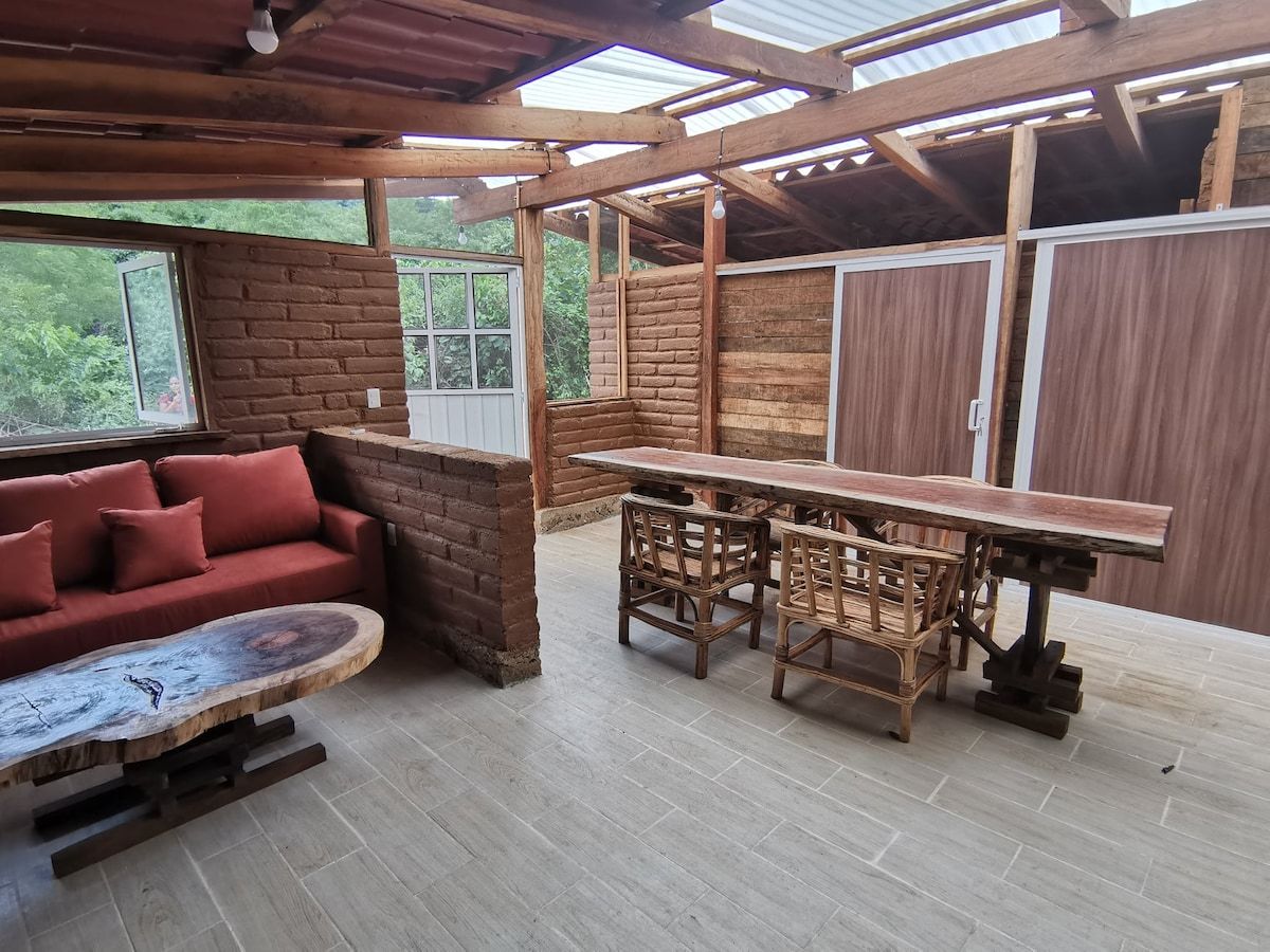 A rustic wooden interior with a sofa, table, and chairs.