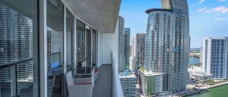Un edificio alto con fachada curva que da vista a una masa de agua.