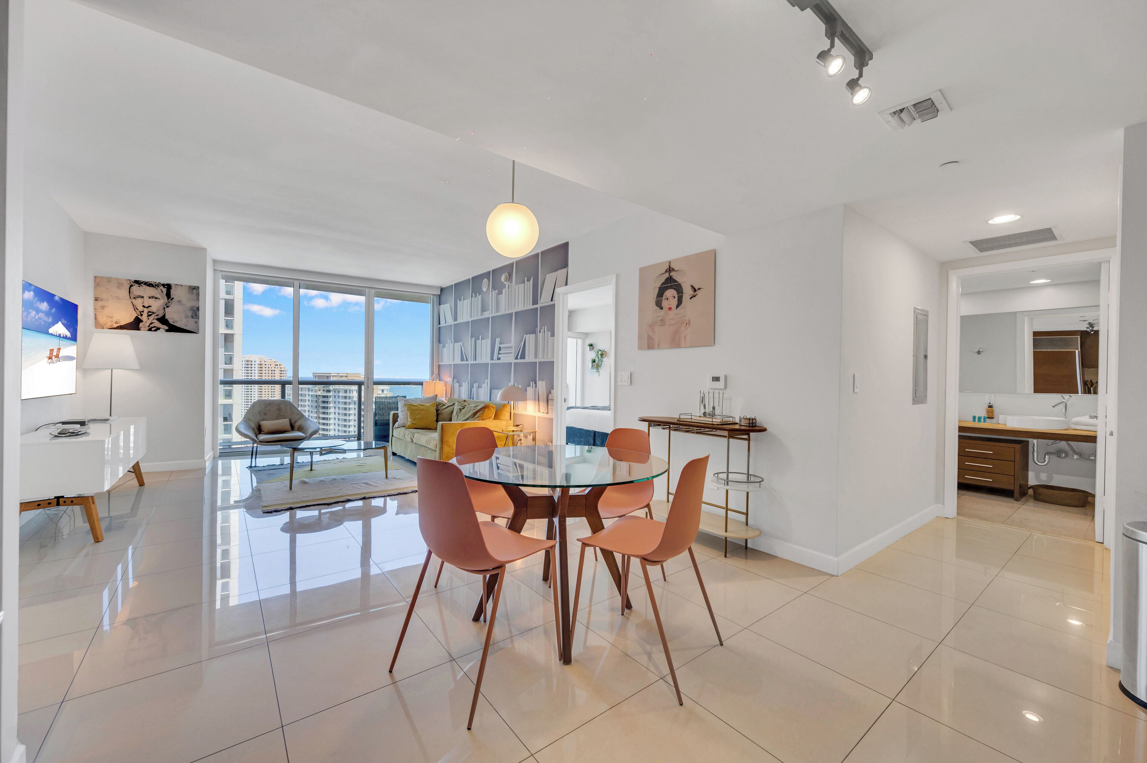 A modern apartment with a dining area, kitchen, and living space.