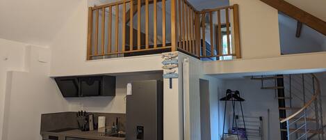 A modern kitchen with a built-in oven, a refrigerator, and a dining area with a table and chairs.