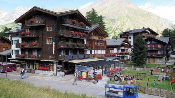 Un hôtel doté de nombreux balcons, d’un espace extérieur aménagé et couvert, et d’un terrain de jeux.