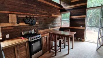 Une cuisine rustique avec des murs en bois, une cuisinière à gaz et une table à manger.