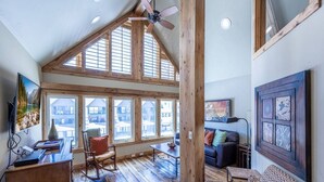 A spacious living room with a high ceiling, wooden beams, large windows, a fireplace, and a cozy seating area. - Labor Day Sale - Limited Time Offer, Save up to 30% (Park City)