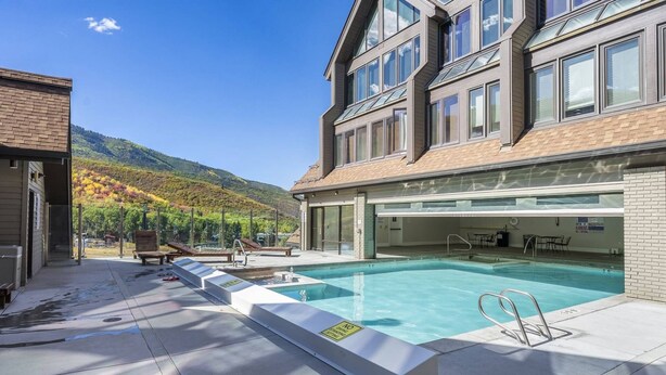 A swimming pool with a no diving sign, lounge chairs, and a view of a mountain. - Labor Day Sale - Limited Time Offer, Save up to 30% (Park City)
