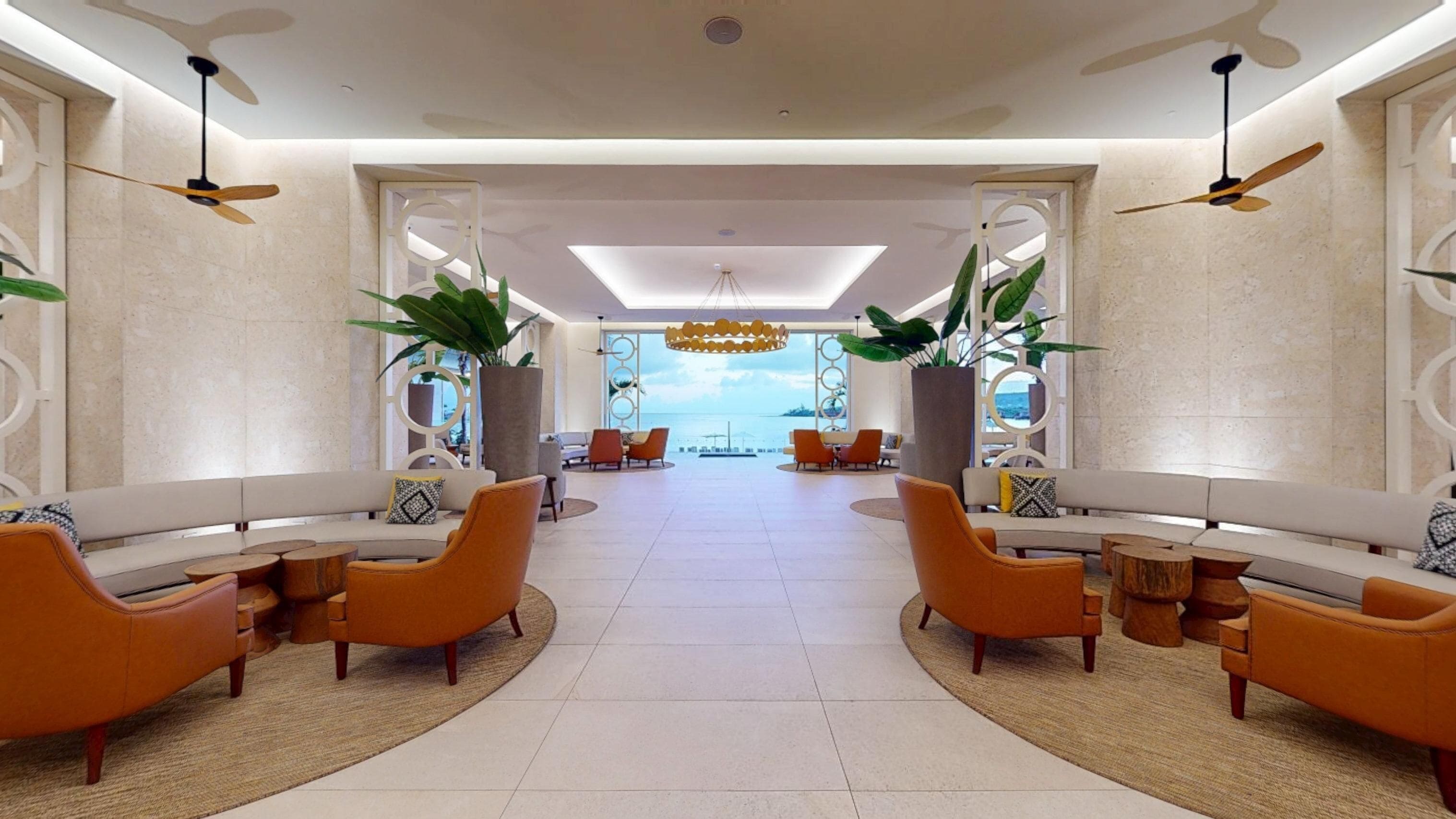 A spacious lobby with a central seating area, large windows, and ceiling fans.