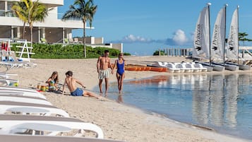 On the beach, white sand, beach cabanas, sun loungers