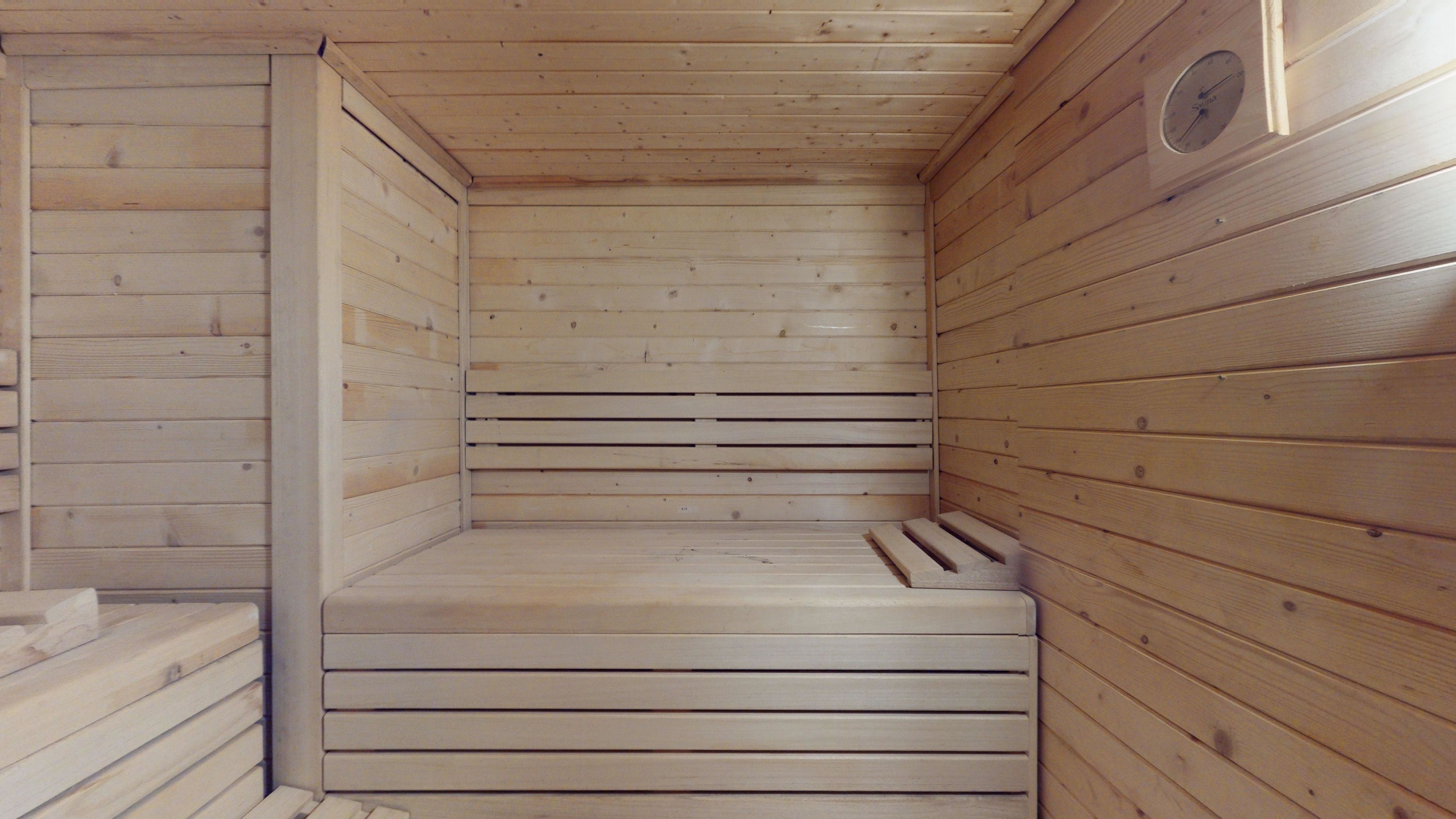 A sauna room with wooden walls and benches.