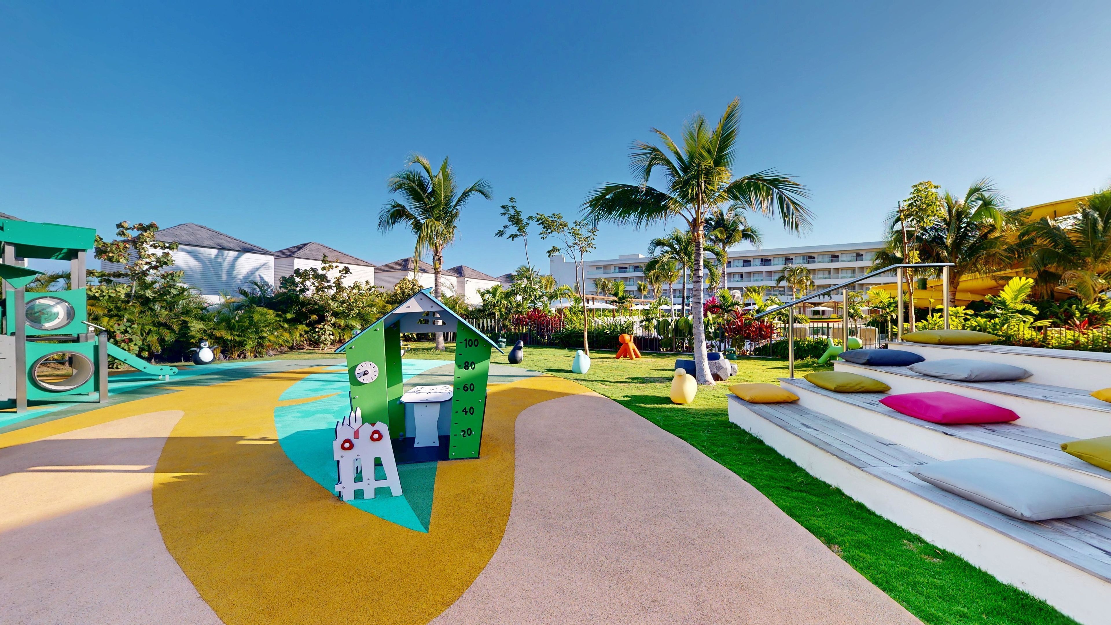 A playground with a climbing structure, a slide, and colorful seating areas.