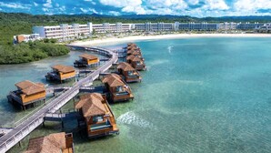 An overwater bungalows connected by a wooden walkway, a beach, and a resort building in the background. - Princess Senses The Mangrove Resort - Adults Only  (Green Island)