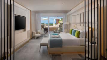 Un moderno cuarto de hotel con una cama grande, un televisor de pantalla plana, una zona de estar con una mesa y sillas, y vistas al exterior.