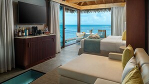 A modern hotel room with a bed, a sofa, a TV, a minibar, and a view of the ocean. - Princess Senses The Mangrove Resort - Adults Only  (Green Island)