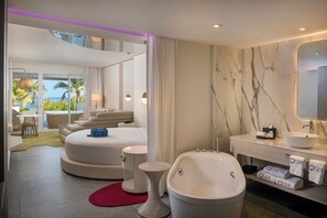 A modern bathroom with a bathtub, vanity, and a large mirror.