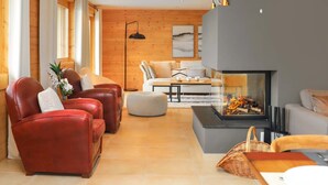 A modern living room with leather sofas, a fireplace, and wooden walls. - Les Mayens 3.2 by Interhome (Champex)