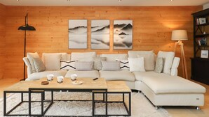 A modern living room with a sectional sofa, a coffee table, and three framed artworks on the wall. - Les Mayens 3.2 by Interhome (Champex)