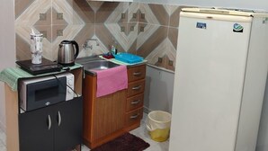 Cocina compacta equipada con microondas, tostadora, hervidor y refrigerador.