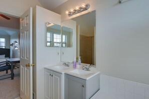 A bathroom with two sinks, a large mirror, and a vanity cabinet. - Owings Mills Townhouse: 8 Mi to Liberty Reservoir! (Owings Mills)