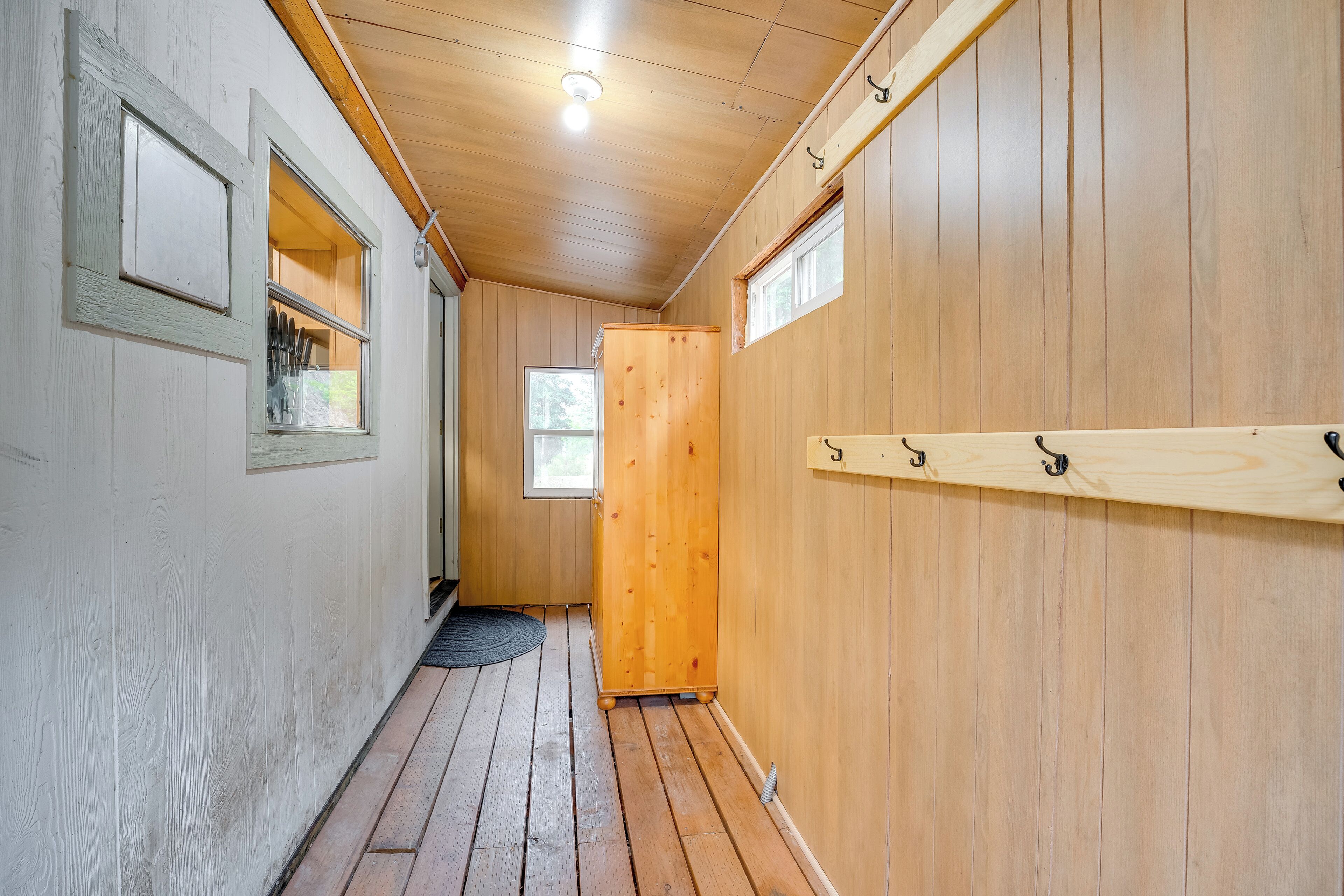 A narrow hallway with wooden walls and a wooden door at the end.