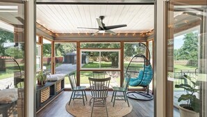 A covered patio area with a ceiling fan, a round table with chairs, and a hanging chair. - Spacious 7 Bedrooms w/ Huge Backyard Downtown ATL (Atlanta)