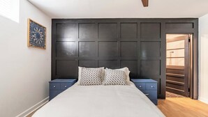 A bedroom with a large bed, dark headboard, two nightstands, and a wooden floor. - Spacious 7 Bedrooms w/ Huge Backyard Downtown ATL (Atlanta)