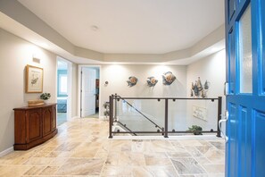 Step into a welcoming space with a polished floor, decorative fish wall art, and a cozy wooden cabinet.