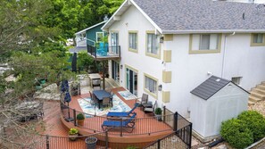 Une maison à deux étages dotée d’un patio, d’un espace extérieur aménagé et couvert, et d’un garage.