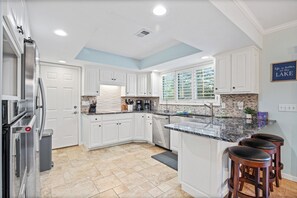 Enjoy cooking in this well-equipped kitchen with a central island, oven, and stainless steel appliances.