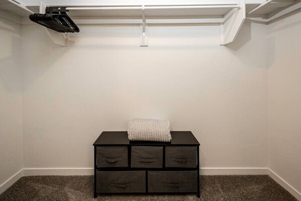 Et værelse med en mørk trækommode, et hvidt håndklæde ovenpå og en lampe i loftet.