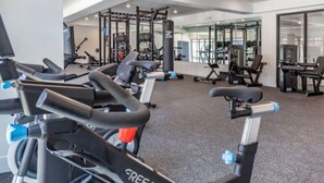 A gym with stationary bikes, weight machines, and a mirrored wall. - Apartment 2110 · Luxury style 2 bed 2 bath apartment (North Salt Lake)