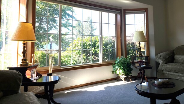 A room with large windows, a piano, a sofa, and two lamps. - Gresham House: Your home away from home... A comfy, cozy corner of Gresham.  (Gresham)