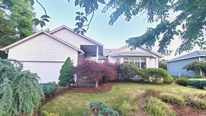 A residential house with a garage, a front yard with various shrubs and a lawn, and a driveway. - Gresham House: Your home away from home... A comfy, cozy corner of Gresham.  (Gresham)