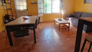 Una sala de estar con comedor, un sofá y un ventilador.