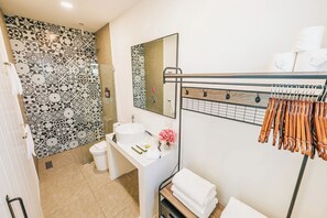 A bathroom with patterned tiles, a sink, a mirror, and a towel rack. - Privada Stays - Private Pools & Colorful-Chic Boutique Hotel - Adults Only (Oranjestad)