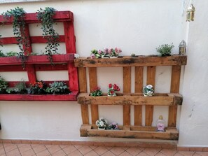 Un jardinier en bois orné de fleurs, placé contre un mur.