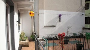 Ein Balkon mit Blumentöpfen und einem Metallgeländer.
