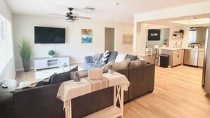 A modern living room with a sofa, a TV, and a ceiling fan. - 3 bedroom house in Crystal River
 (Crystal River)