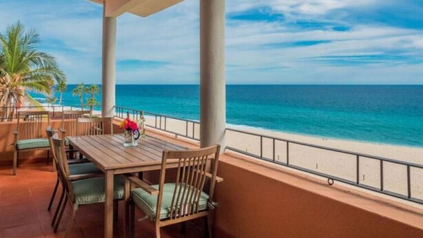A covered outdoor seating area with a view of the ocean.