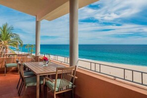 A covered outdoor seating area with a view of the ocean.