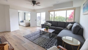 A modern living room with a gray sectional sofa, a small coffee table, and a patterned rug. - 1 Medallion Modern City 7 rooms 20+ Views with AC (San Diego)