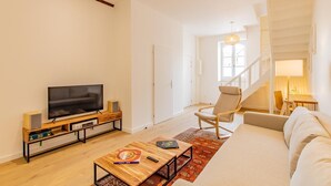 A modern living room with a flat-screen TV, wooden coffee table, and a sofa. - Le Meix - GIVRY - Gîte (GIVRY)