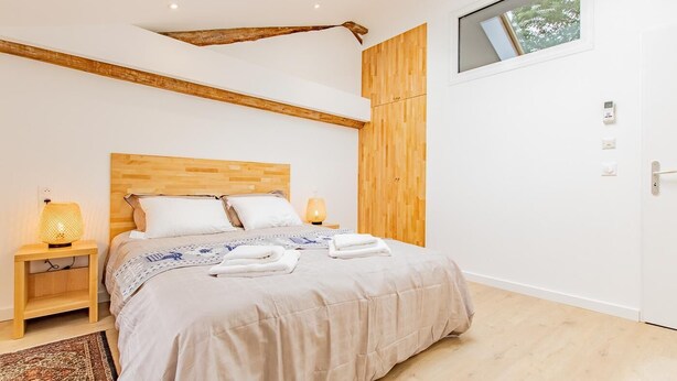 A modern bedroom with a wooden headboard, a skylight, and a large window. - Le Meix - GIVRY - Gîte (GIVRY)