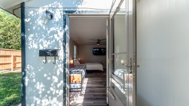 Ein modernes Wohnmobil mit einem Schlafbereich, der ein Bett, einen Deckenventilator und einen Fernseher bietet.
