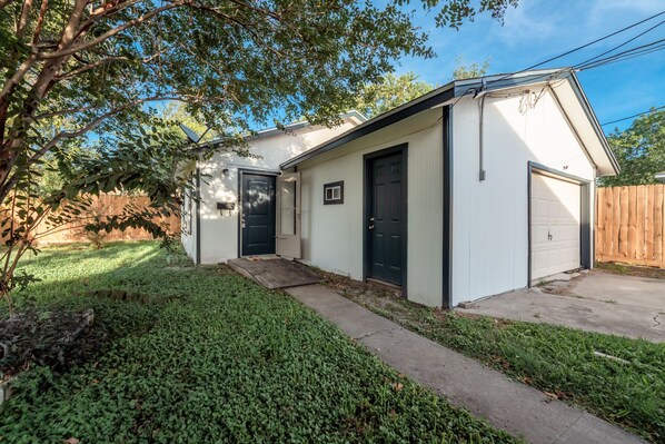 Une maison de plain-pied avec une porte d’entrée, un garage et un petit porche.