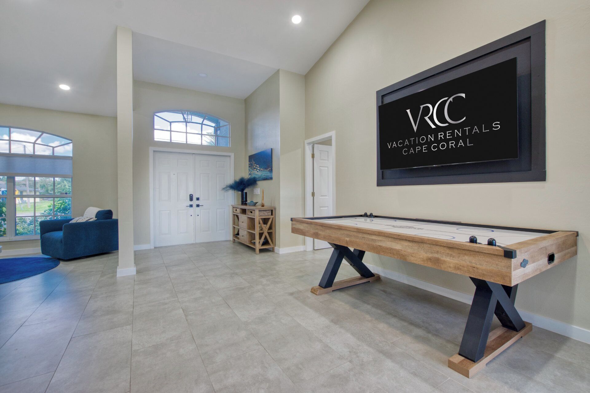 A spacious room with a pool table, a large window, and a door leading to another room.