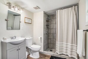 Une salle de bain avec un lavabo, des toilettes et une douche.