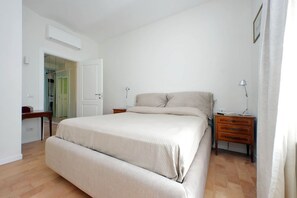Ein Schlafzimmer mit Bett, Nachttischen, Schreibtisch und Kleiderschrank.
