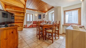 Un intérieur en bois comprenant un coin repas, un téléviseur et un comptoir de cuisine.