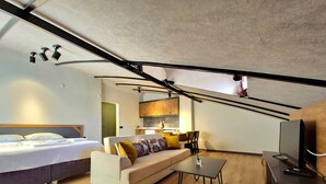 Een knus woongedeelte met een bed, bank en een klein tafeltje.