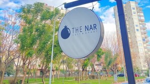 Een bordje met 'The Nar', een granaatlogo, dat een restaurant of eetgelegenheid aangeeft.