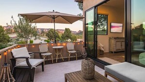 A balcony with outdoor seating, a large umbrella, and a view of the mountains. - NEW! Serenity & Style in Sedona - Pool, Red Rock Views, & more! (Sedona)